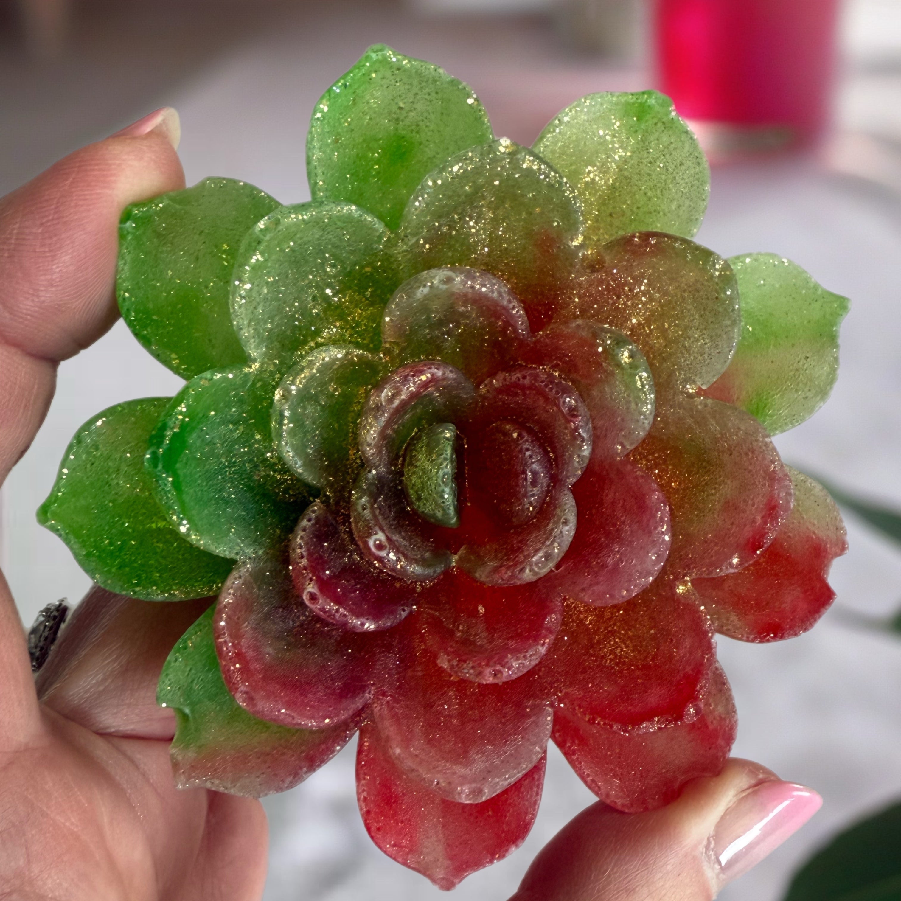 Gummy candy shaped like a lotus flower held by a hand.